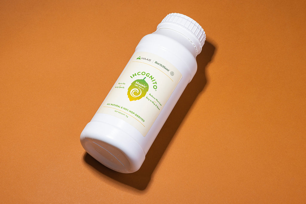 Jug of INCOGNITO liquid hop extract on an orange background